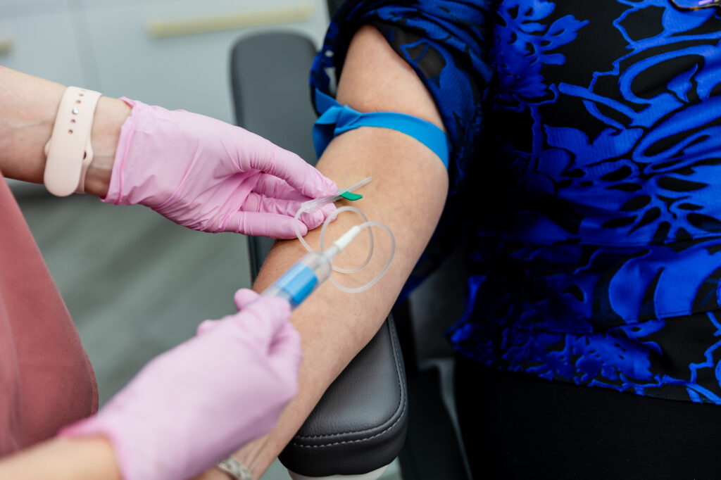 Close up of gloved hands administering IV therapy near Macomb, MI.