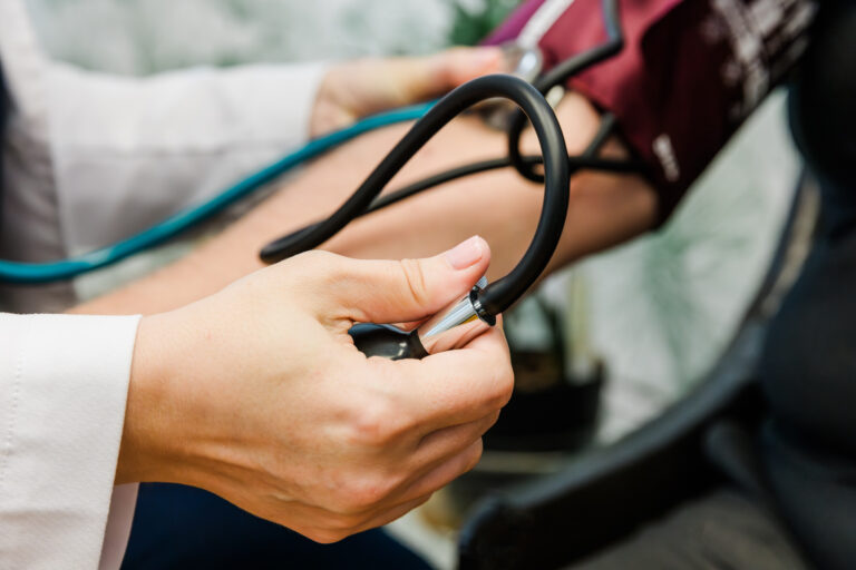 Close up of a provider checking a patients heart rhythms, performing integrative medicine in Sterling Heights.